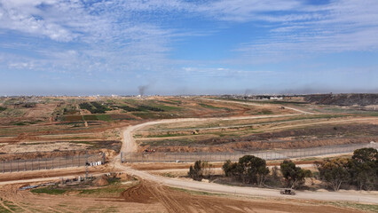 Naklejka premium Aerial Road Leading Toward Gaza Border Area showing a rural road leading toward the Gaza border through open fields in 2024. 