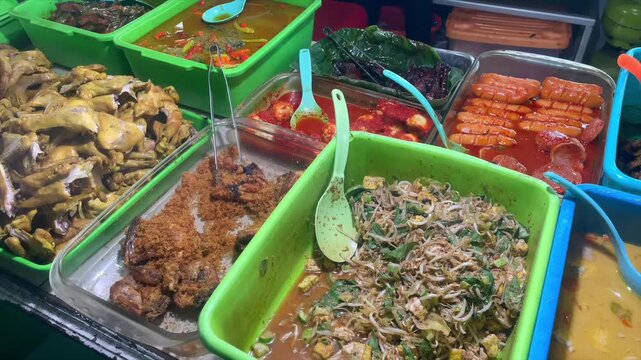 Variety of traditional indonesian side dishes displayed in a local food stall or warung.
