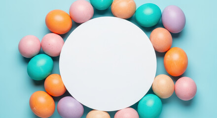Colorful pastel easter eggs arranged in circular frame around blank white round card on light blue background for festive spring design