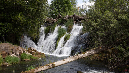 Obraz premium Layered Waterfall Cascades Over Mossy Rock in the Pacific Northwest