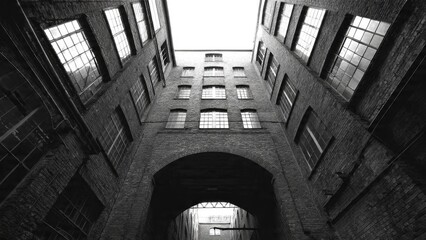 Dramatic black and white interior of historic brick building with archway