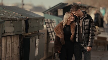 A romantic couple embraces near the Seine River in Paris France on a sunny day. This image is suitable for travel lifestyle and relationship content.