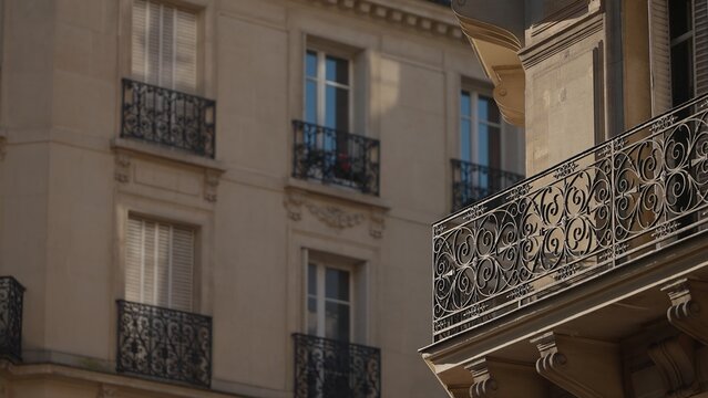 Close-up of Parisian architecture featuring ornate balconies and windows in France. This European city building showcases intricate ironwork railings and classic shutters perfect for travel and touris