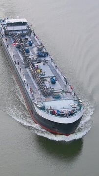tracking ship vessel transporting logistics river canal scene critical role inland motor freighter oil tanker from front aerial drone shot view 