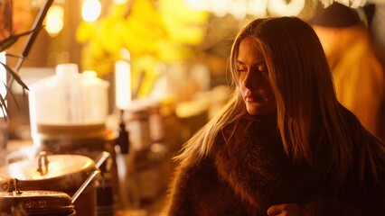 A romantic woman in Paris France is wearing a fur coat with a golden light bokeh background. This...