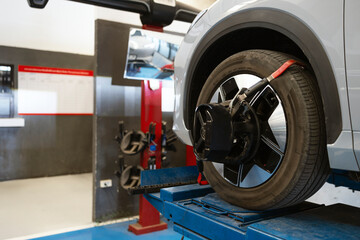 Car wheel alignment service using digital equipment in modern auto repair shop