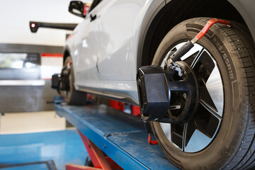 Car wheel alignment service using digital equipment in modern auto repair shop