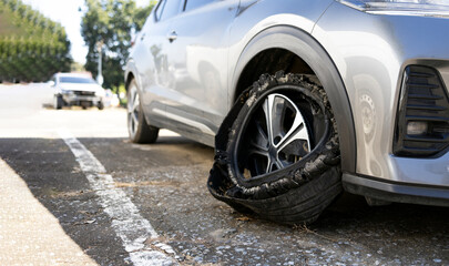 Car with blown tire stopped on roadside showing vehicle breakdown and road safety risk