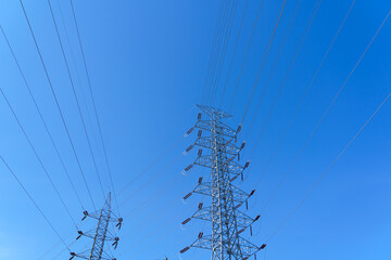 High-voltage power poles supplying electricity to the city, with the sky as a backdrop.