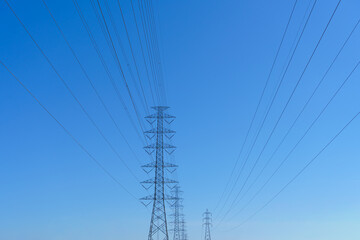 High-voltage power poles supplying electricity to the city, with the sky as a backdrop.