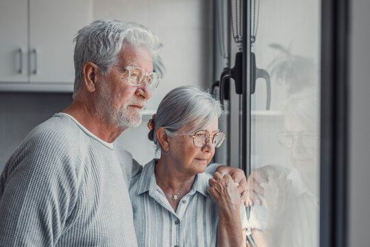 Anxious scared elderly couple embracing, facing troubles together. Family love, senior years in trust, health issue, mutual support empathy in crisis, wife consoling thoughtful husband look out window