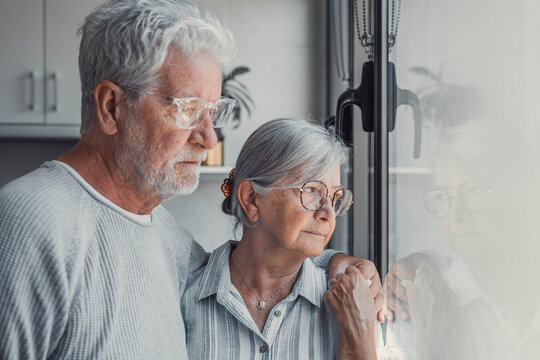 Anxious scared elderly couple embracing, facing troubles together. Family love, senior years in trust, health issue, mutual support empathy in crisis, wife consoling thoughtful husband look out window