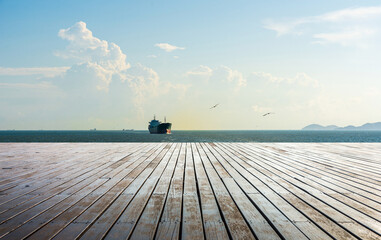 Tranquil Seascape with Dock and Cargo Ship Under Blue Sky