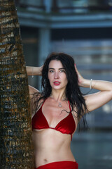 Glamorous Woman in Red Bikini Against Tropical Backdrop