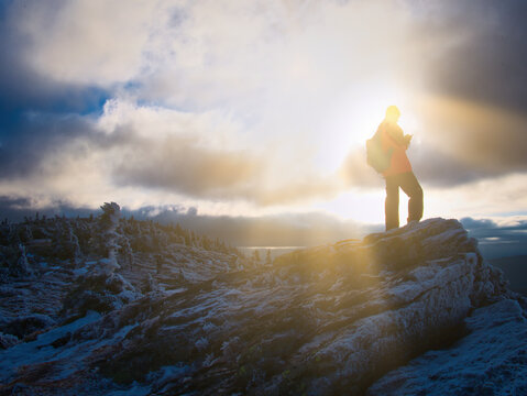 Tourist man on a mountain range using phone in a harsh scenic landscape of a mountain range of Jeseniky mountains