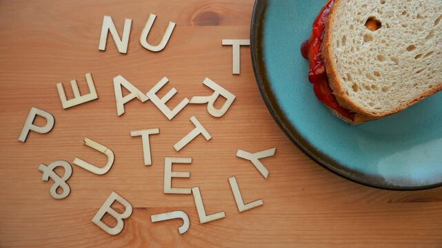Peanut butter & jelly in animated stop motion wood letters and a peanut butter and jelly sandwich.
