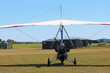 	
Ultralight airplane standing on a grass runway	