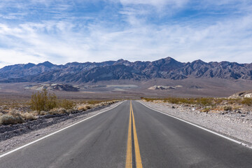 Naklejka premium Alluvial deposits. Death Valley National Park, Inyo County. California State Route 190. In the distance is Black Mountains (Amargosa Range System).