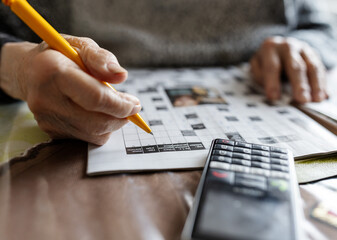 Solving a crossword puzzle with a mobile phone nearby