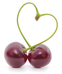 Two sweet cherries in heart shape isolated on white