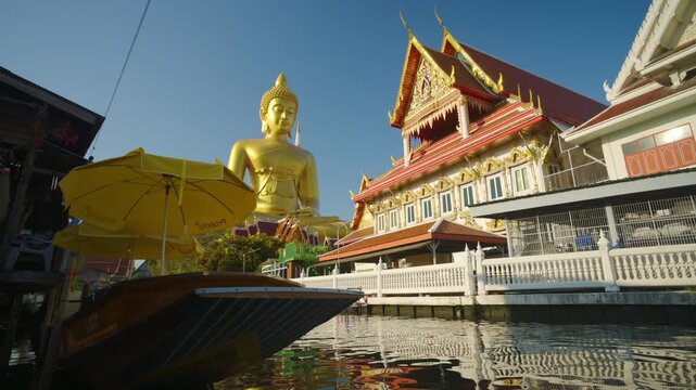 Wat Paknam Bhasicharoen temple big gold buddha statue with wooden tradition travel boat in Bangkok, Thailand