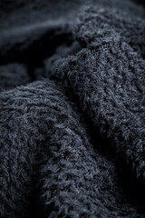 The fabric of black fleece, a synthetic knit with a soft, fluffy texture