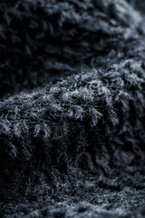 The texture of a soft black fleece fabric with visible fibers and folds