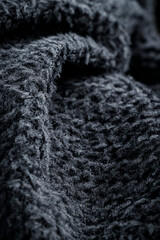 The fabric of black fleece, a synthetic knit with a soft, fluffy texture