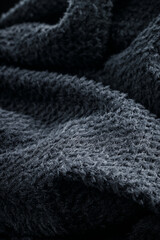 The texture of a soft black fleece fabric with visible fibers and folds
