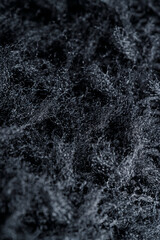The texture of a soft black fleece fabric with visible fibers and folds