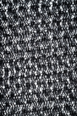 The fabric of black fleece, a synthetic knit with a soft, fluffy texture