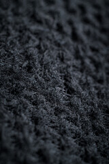 The fabric of black fleece, a synthetic knit with a soft, fluffy texture