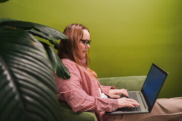 Email writing on laptop in retail lounge, woman types business messages. Remote work, online meeting, cloud documents. Ecommerce reporting, digital marketing tasks, social media management, internet.