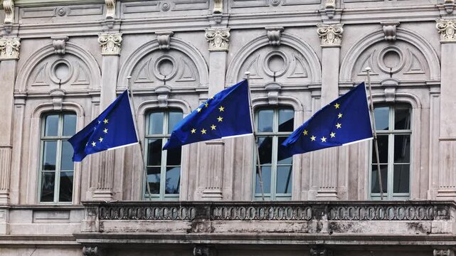 Eu Blue Flags With Yellow Stars Fluttering On A Pole On A Vintage Facade of building
