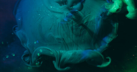 Dye spill. Blur paint wave. Sparkling green blue acrylic liquid pouring on art sphere. Color water shimmering mix bokeh light abstract background.