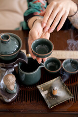 Tea drinking tradition. Chinese ceremony. Female hand holding fresh bergamot beverage figurine spiritual steam aromatherapy for meditation incense ritual enlightenment.