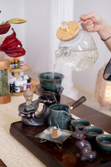 Water pouring. Tea ceremony. Woman hands filling glass teapot with drinking refreshing liquid healthy lifestyle burning incense.