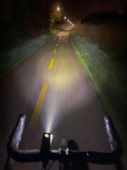night cycling on illuminated road with headlight