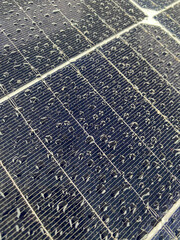 angled view of wet solar panel with raindrops