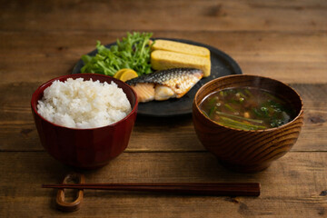 Japanese breakfast set on rustic wooden table with mackerel and tamagoyaki