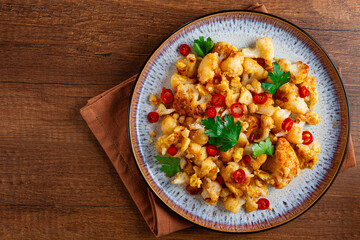 spicy fried cauliflower served on a wooden countertop,