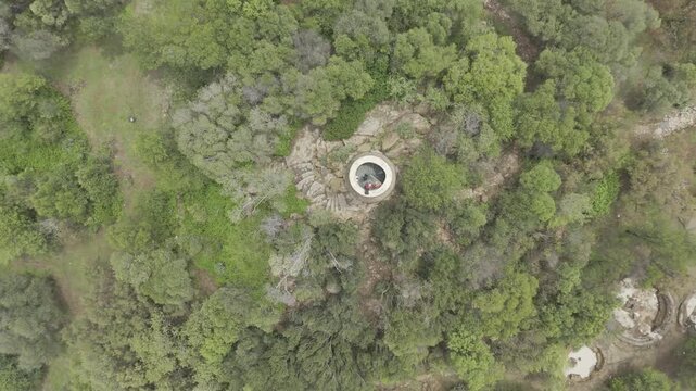 Drone flies up with camera pointing down over tower in Credo Mutwa Cultural Village, Soweto, South Africa