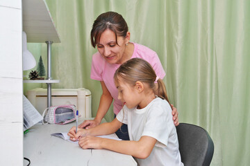 Mother helping daughter to complete school tasks.