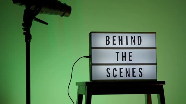 BTS. Behind the scene light box in front of vdo camera frame. Black text on white lightbox of word Behind the scenes. Prop for filmmaker in studio lights. BTS Footage for video production making of.