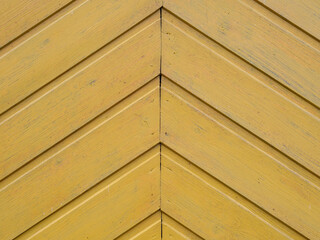 Wooden herringbone background. A fragment of an old wooden door. Old vintage diagonal planked wooden texture