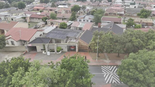 Drone follows parallel to a group of tourists walking the historic route on rainy day in Soweto, South Africa