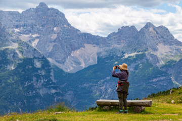 Woman hiker on tourist trail in Dolomites mountain