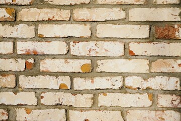 Alter beige-wei&szlig;e Backsteinfassade als Hintergrund