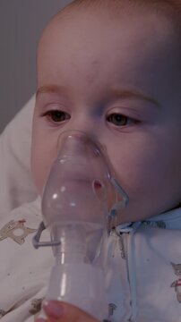 Infant receiving non-invasive nebulization treatment at home, close-up view of child with mask, gentle camera zoom in, showcasing care and comfort during therapy session