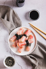 Fried spring rolls with crab sticks and nori on a plate on the table top and vertical view